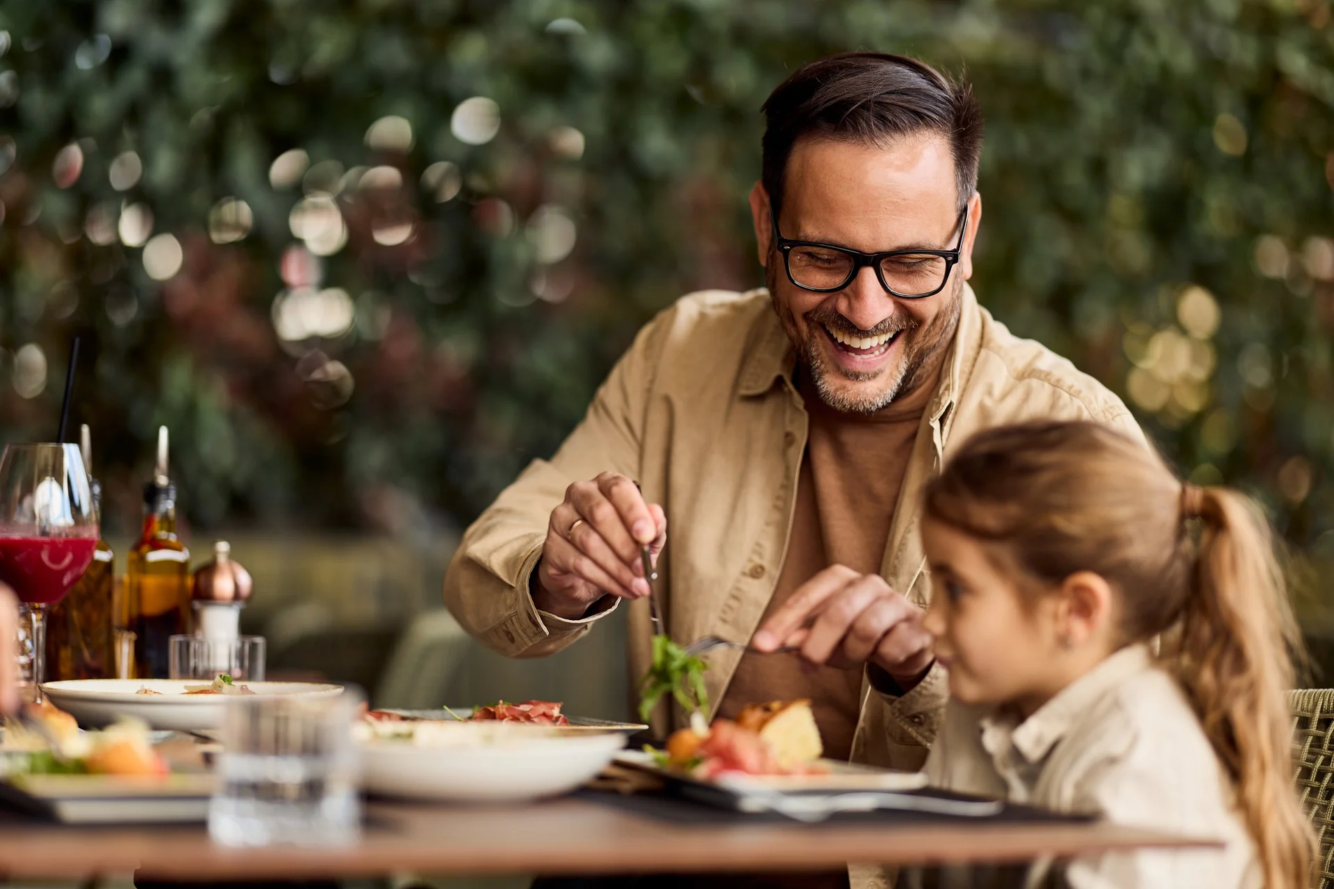 Father and daughter enjoying lunch on restaurant patio